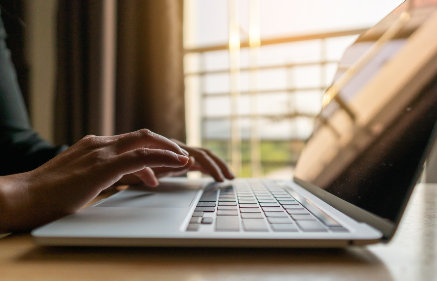 laptop on desk with person typing 