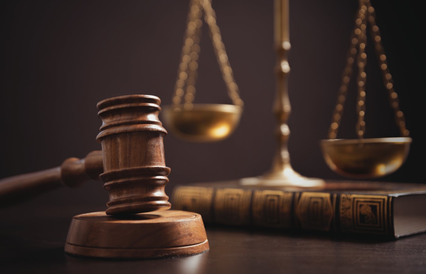 close up of a gavel, legal scale, and book