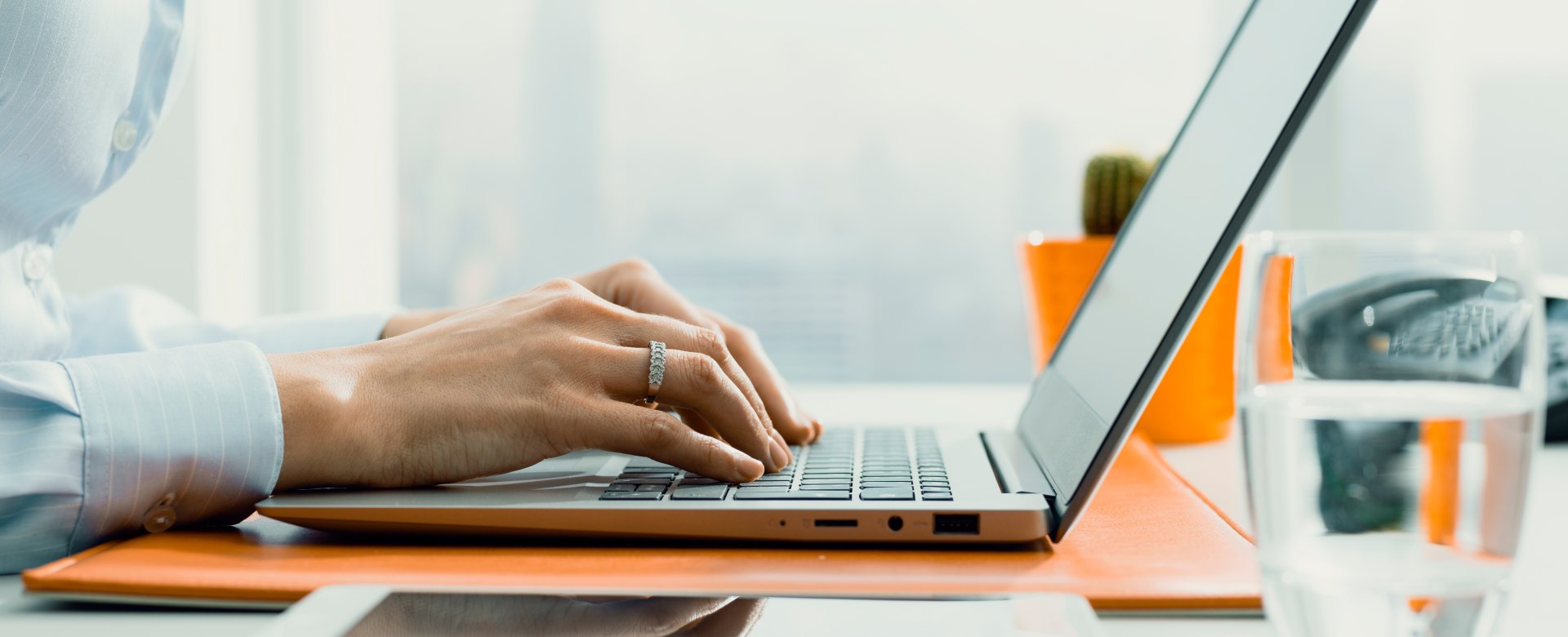 person with hands on laptop keyboard